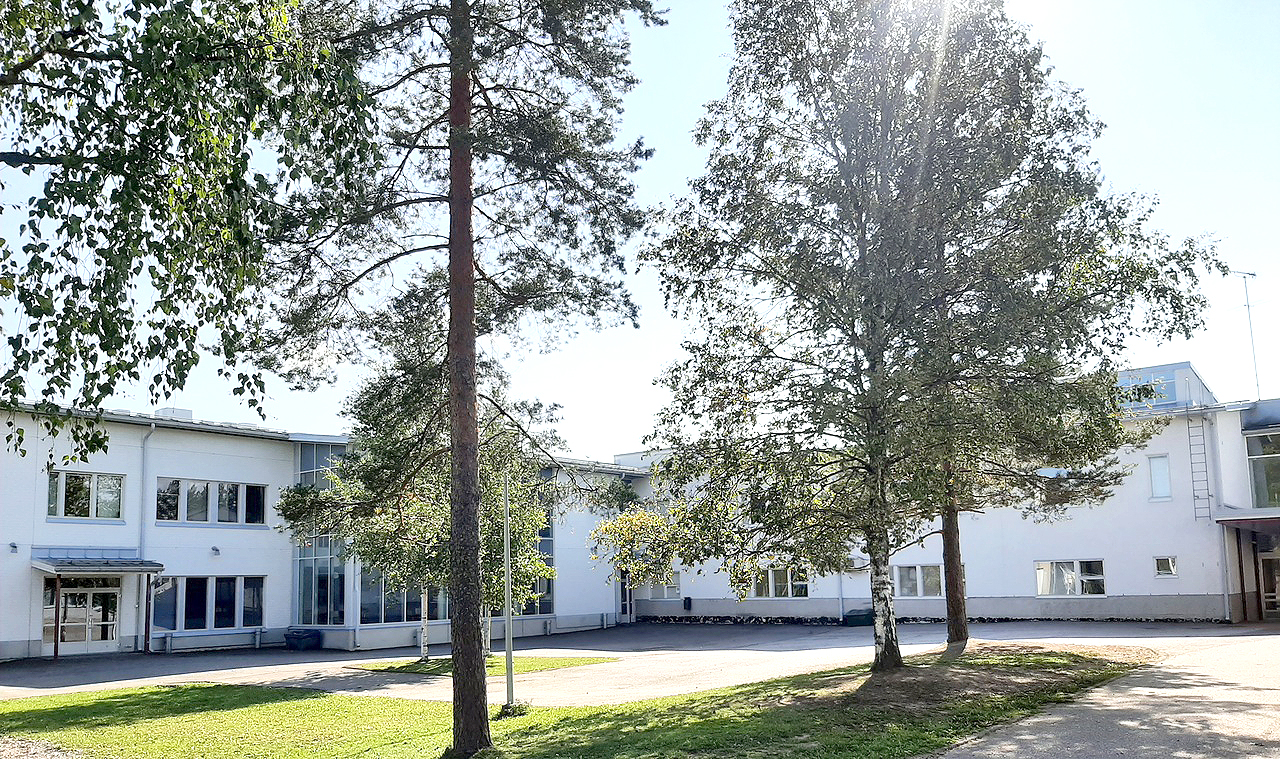 Askolan yläkoulu, vaalea koulurakennus, jonka edessä puita