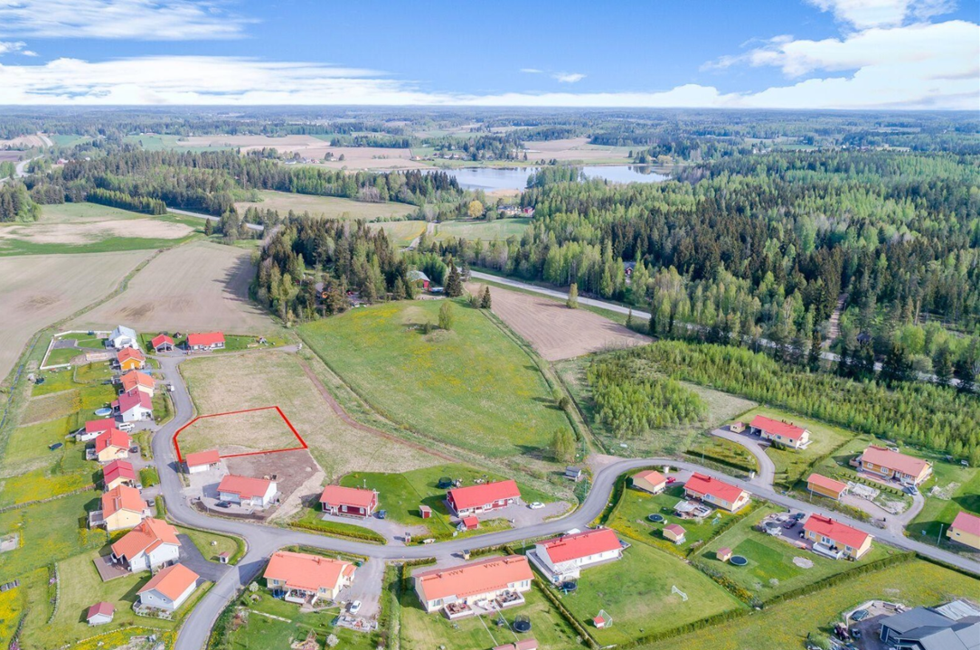 ilmakuva Askolan Monninkylän omakotitaloalueesta, jossa punakattoisia rakennuksia. Yksi tonteista merkitty punaisella viivalla.