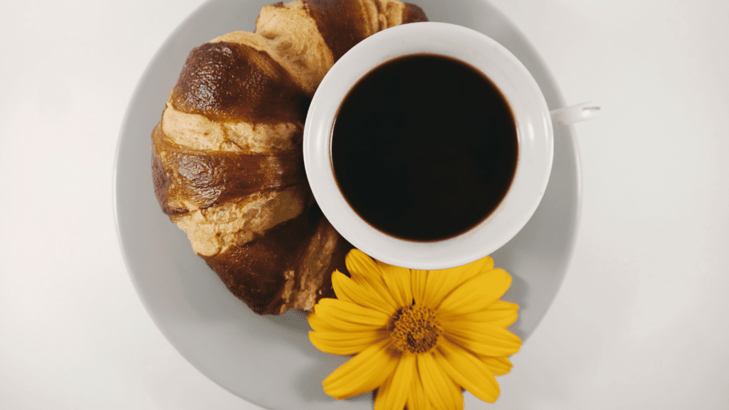 croissant, kahvi ja kukka