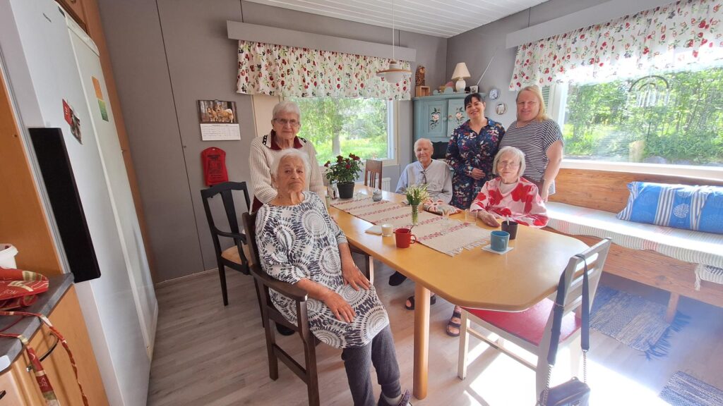 Ikäihmiset koolla ruokapöydän ääressä Perhekoti Laurilassa