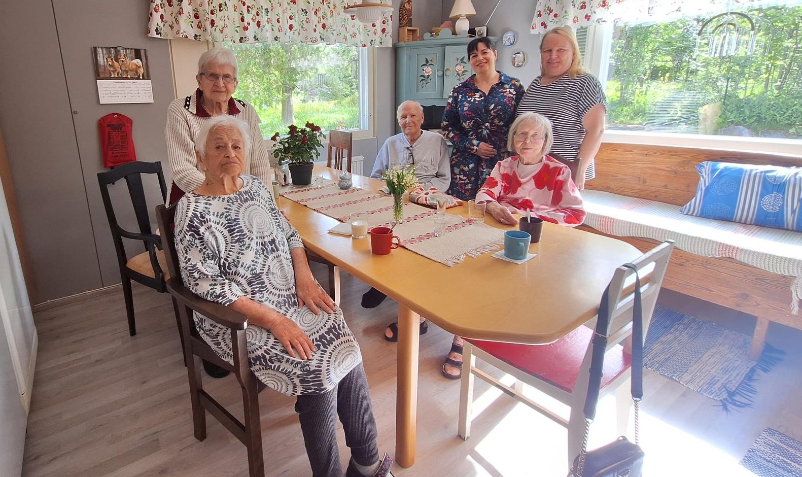 Ikäihmiset koolla ruokapöydän ääressä Perhekoti Laurilassa