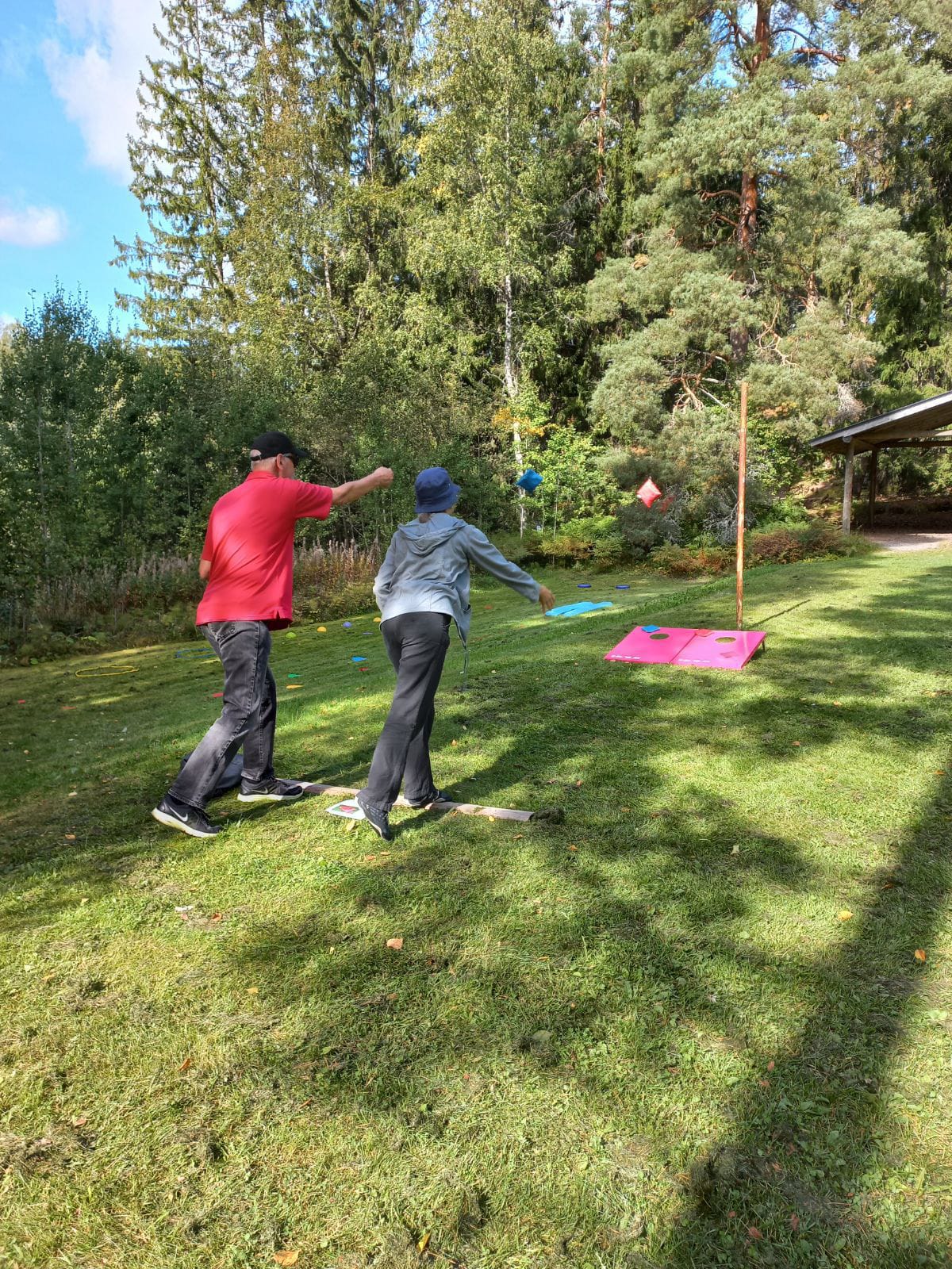 kaksi ihmistä pelaamassa heittopeliä nurmialueella